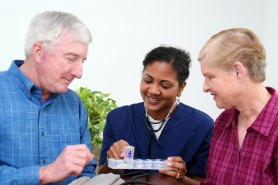 Minority woman giving healthcare to senior at home